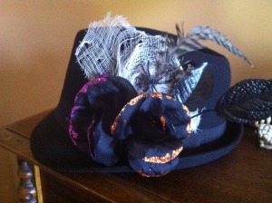 This darling little hat is decorated with black and glitter roses, cheesecloth, feathers, and a spider.